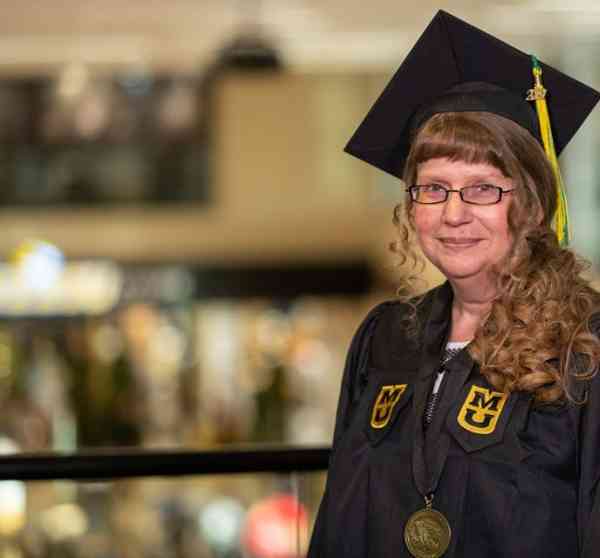 Jennifer Logiudice, radiologic science BHS, wearing her graduation cap and gown at Mizzou's student center.